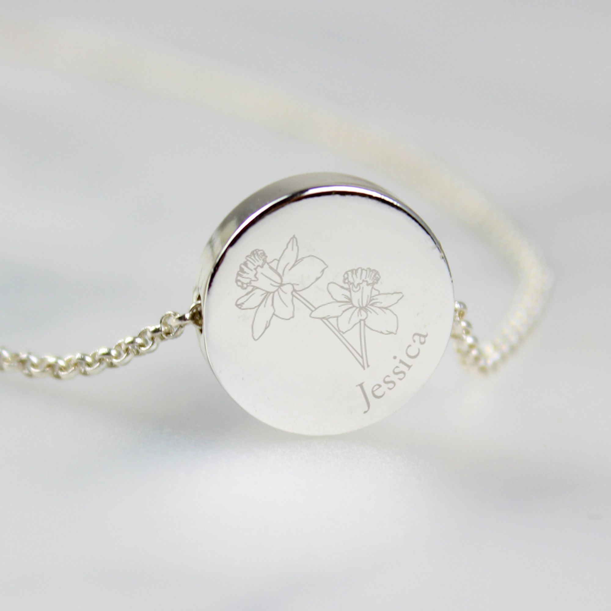 Close up of personalised March birth flower necklace with daffodil design and engraved name
