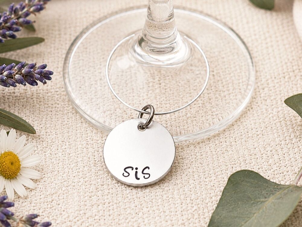 Personalised wine glass charm with hand stamped guest name on a wine glass