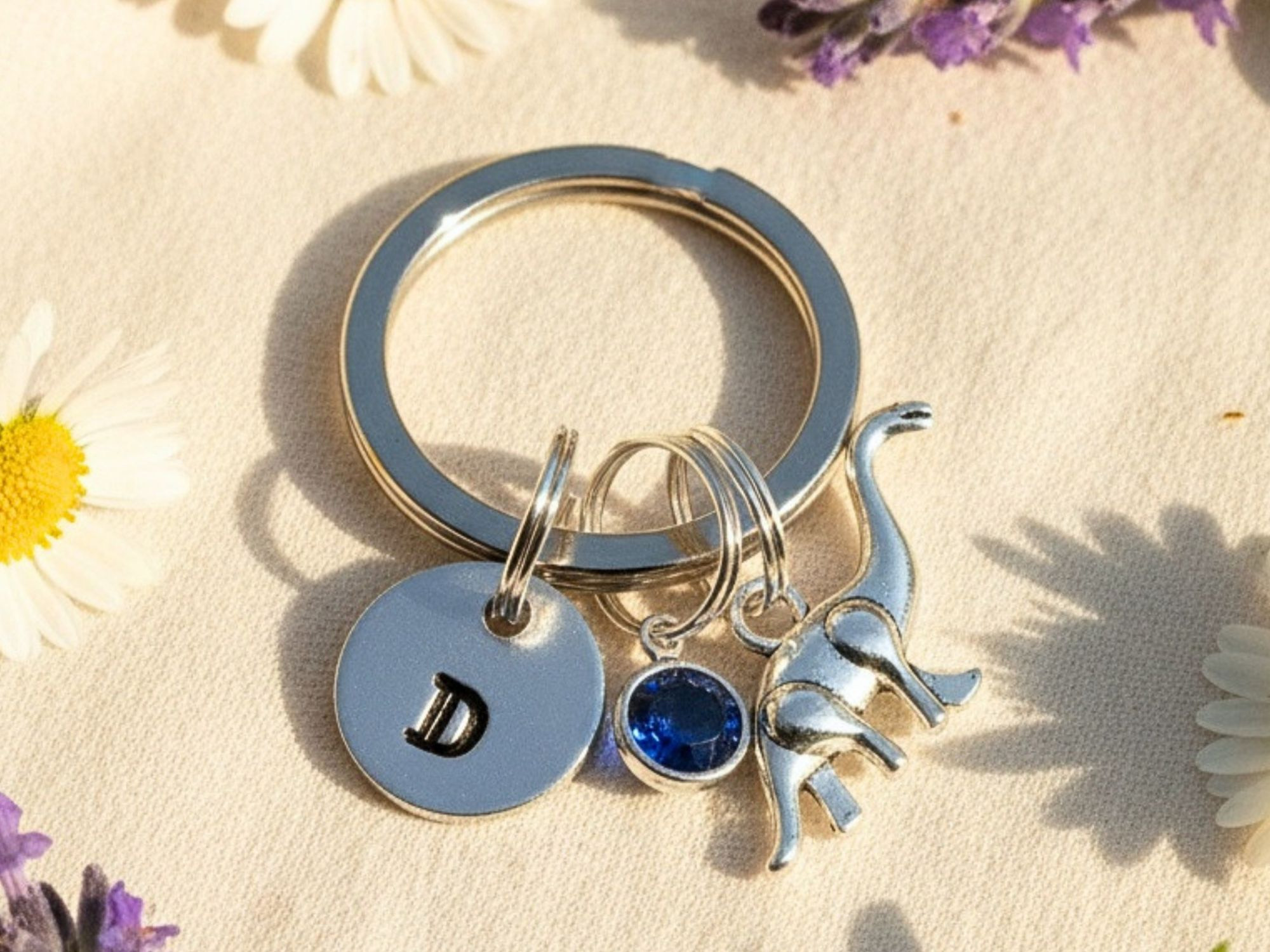 Hand stamped aluminium brontosaurus keyring with personalised initial and birthstone crystal