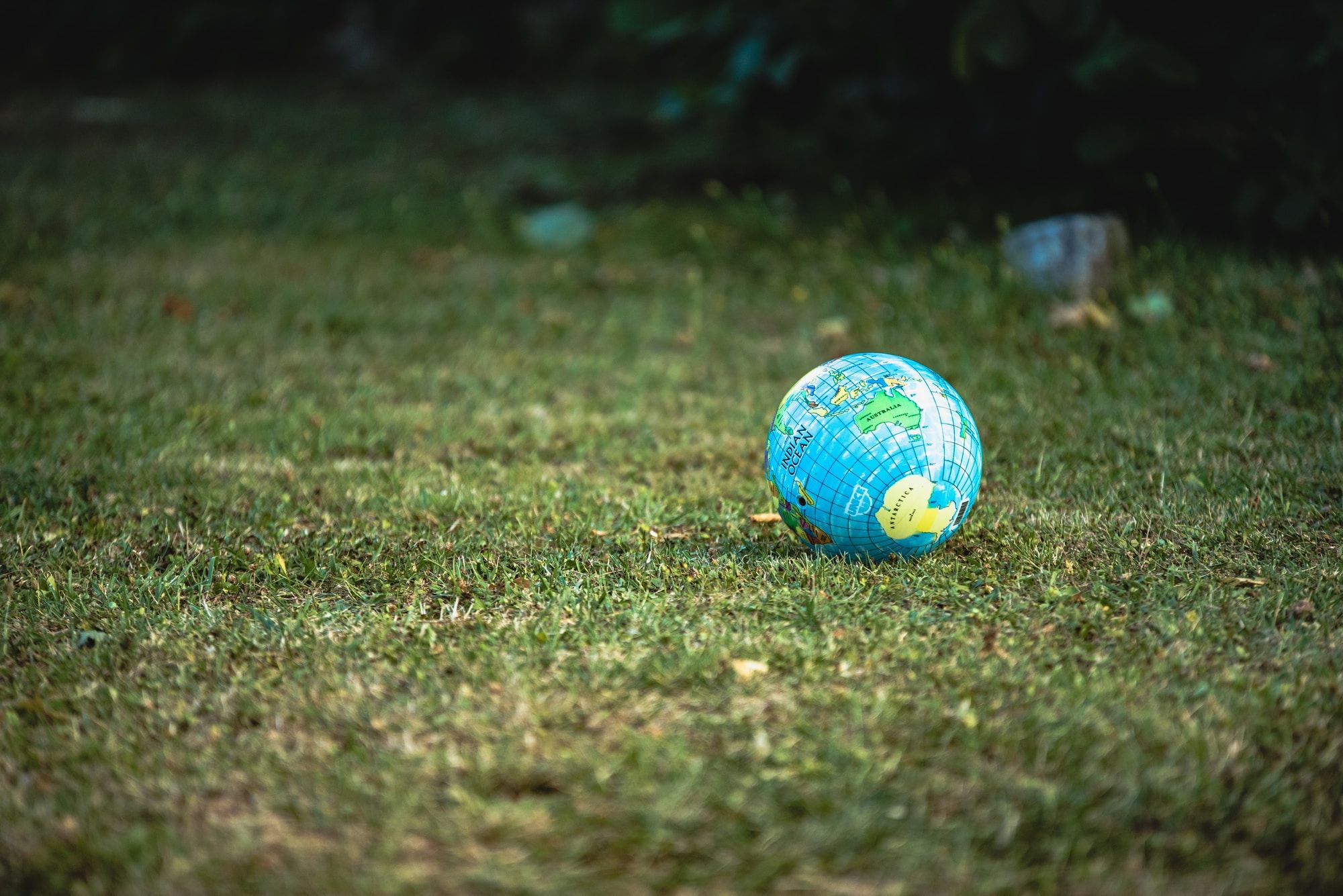 A globe of the world situated on grass