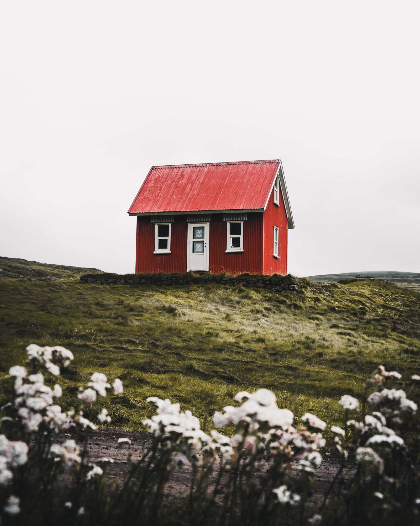 A small red house standing alone in the countryside