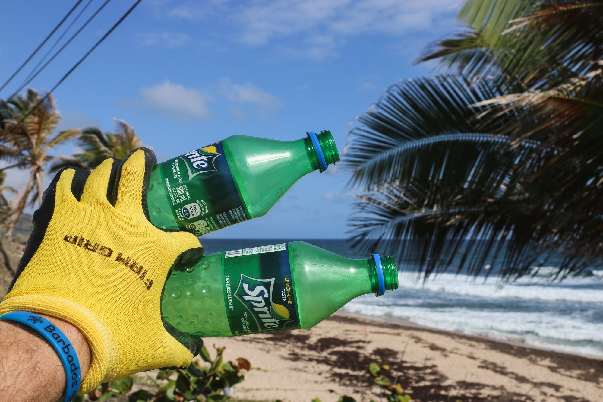Beach Cleaner Picking Up 2 Plastic Sprite Bottles