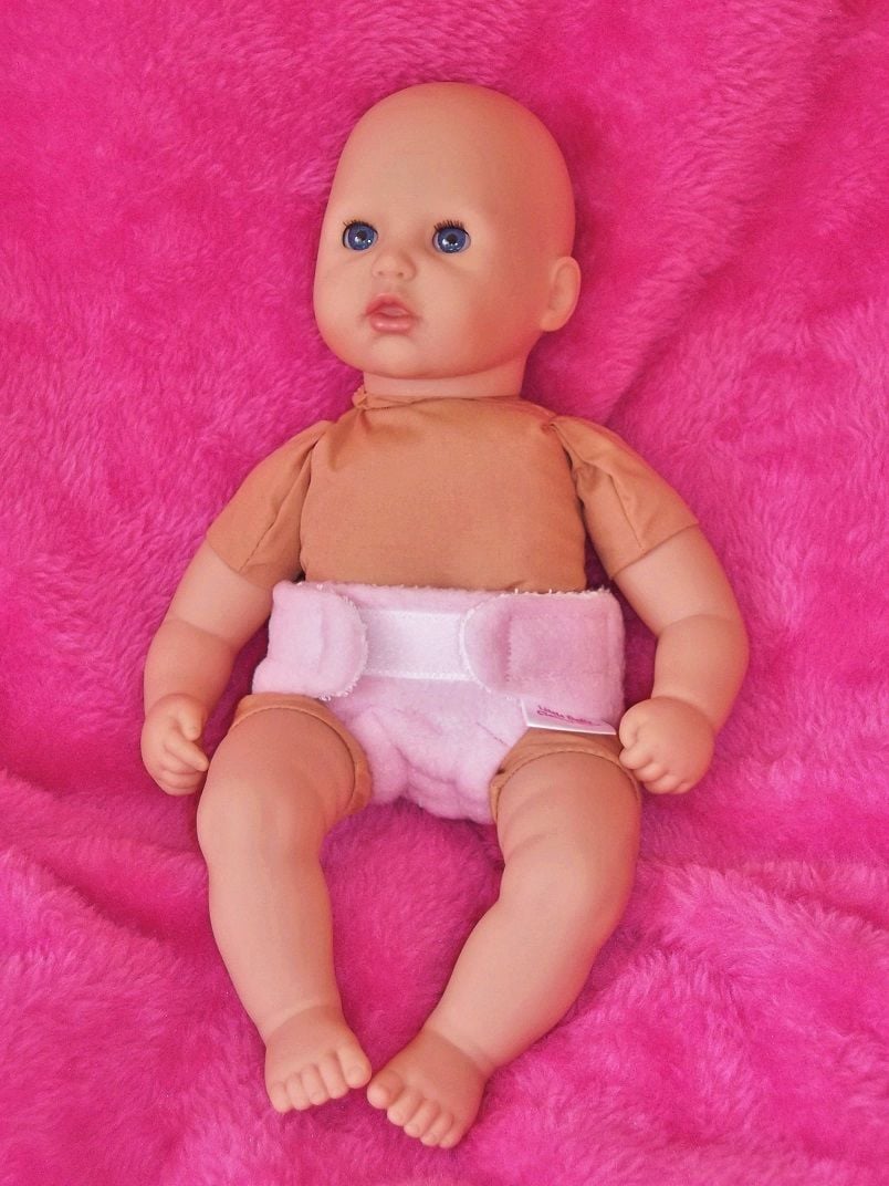 Doll wearing a pink nappy