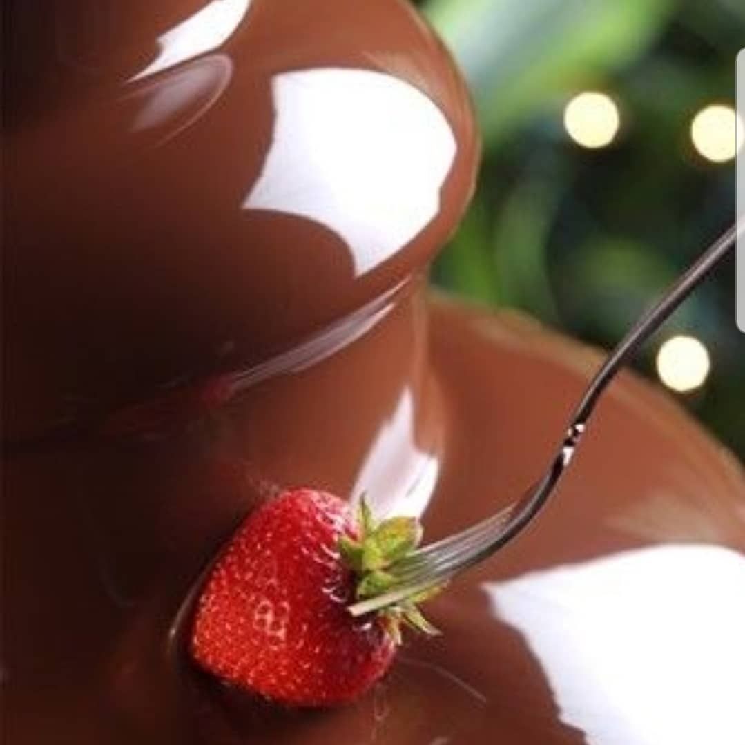 Chocolate Fountain close up image of Chocolate cascade and strawberry