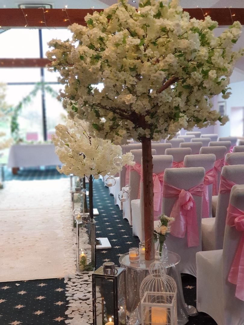 Blossom Tree Aisle Decor with lanterns, white carpet, chair covers and pink
