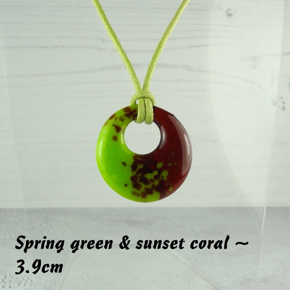 Handcrafted spring green & sunset coral fused glass off-set round pendant on a waxed cotton cord with lobster clasp (#44)