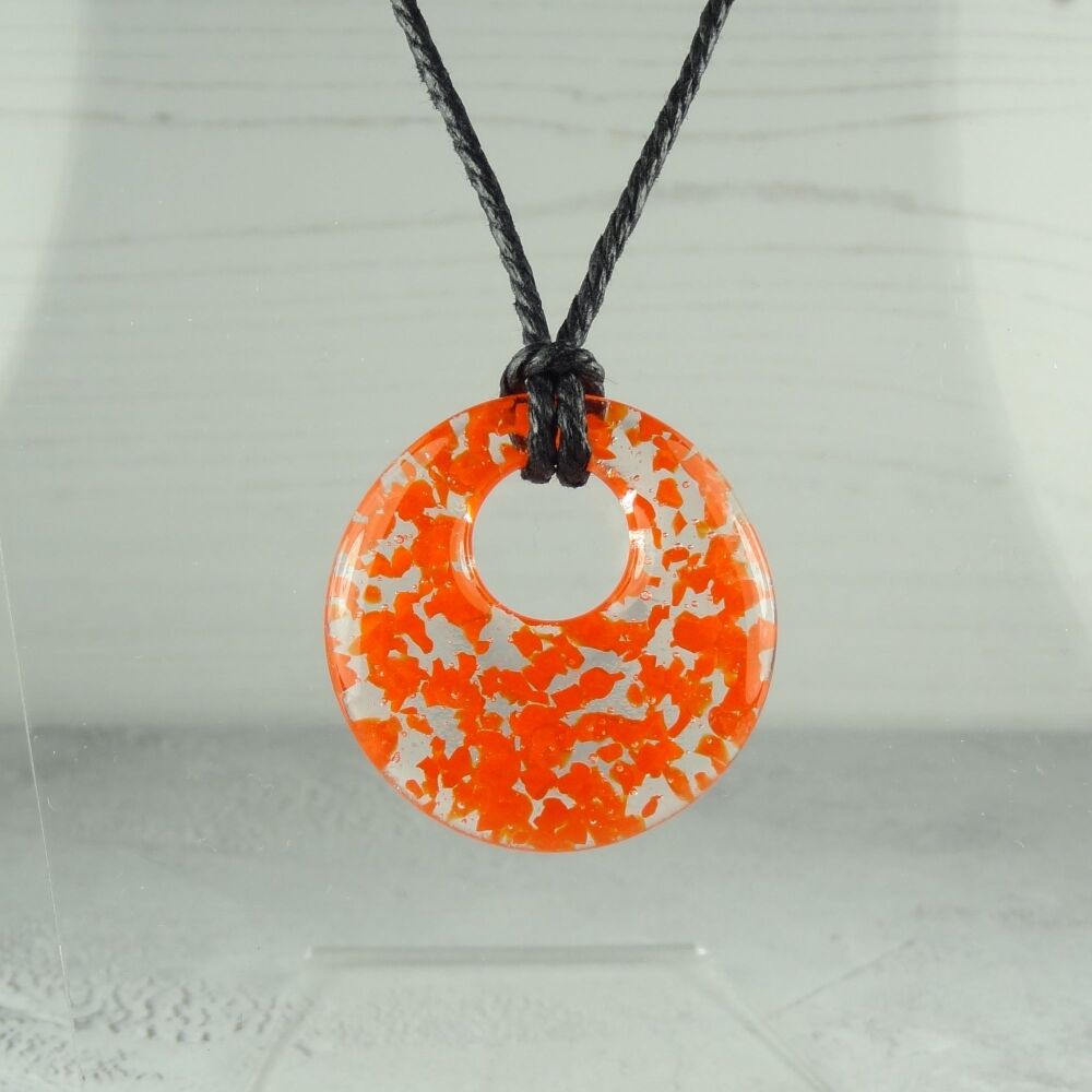 Handcrafted orange fused glass off-set round pendant on a waxed cotton cord