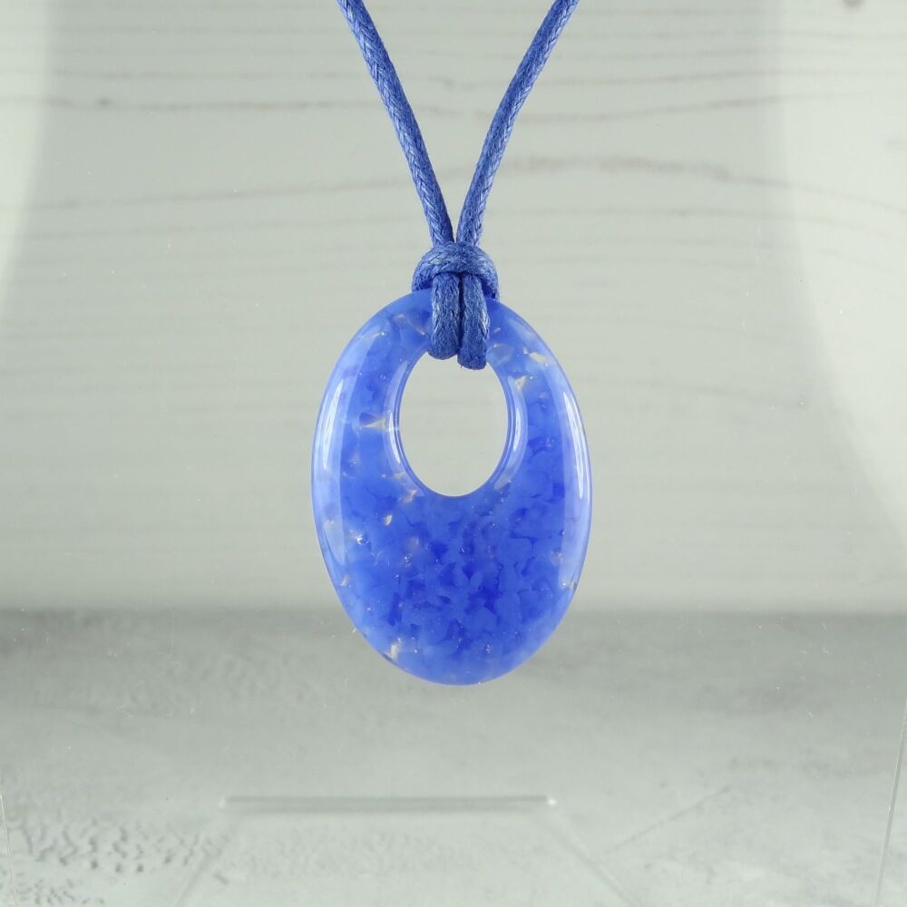 Handcrafted cornflower blue fused glass off-set oval pendant on a cord