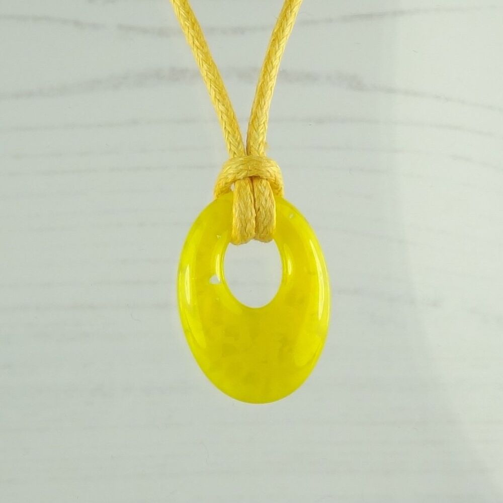 Handcrafted yellow fused glass off-set oval pendant on a waxed cotton cord 