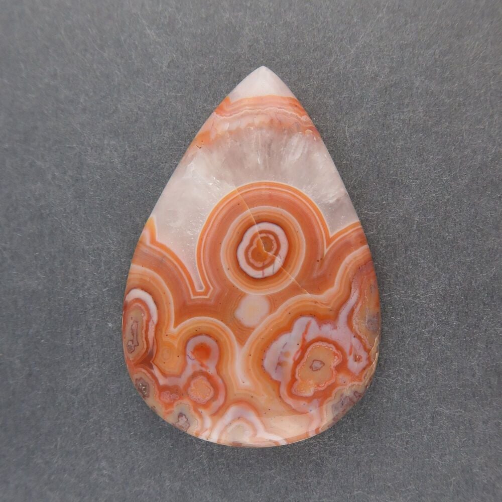 Orbicular agate cabochon with quartz crystal growth