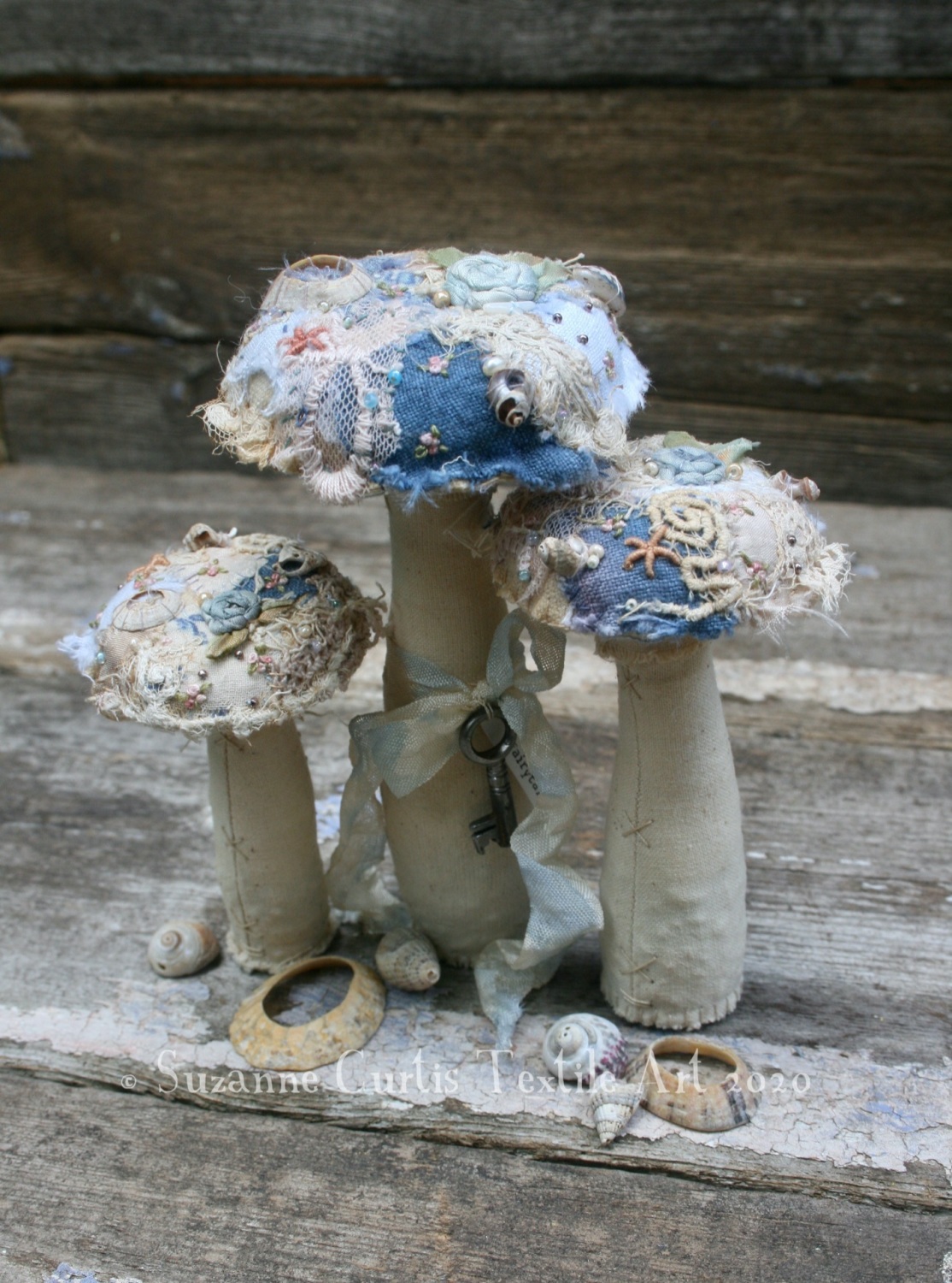 A trio of embellished textile toadstools