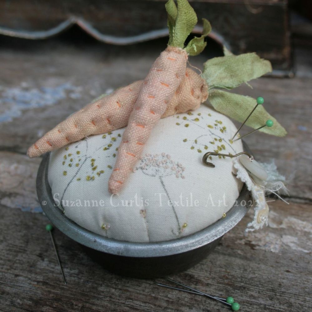 A vintage tin pincushion with carrots - O