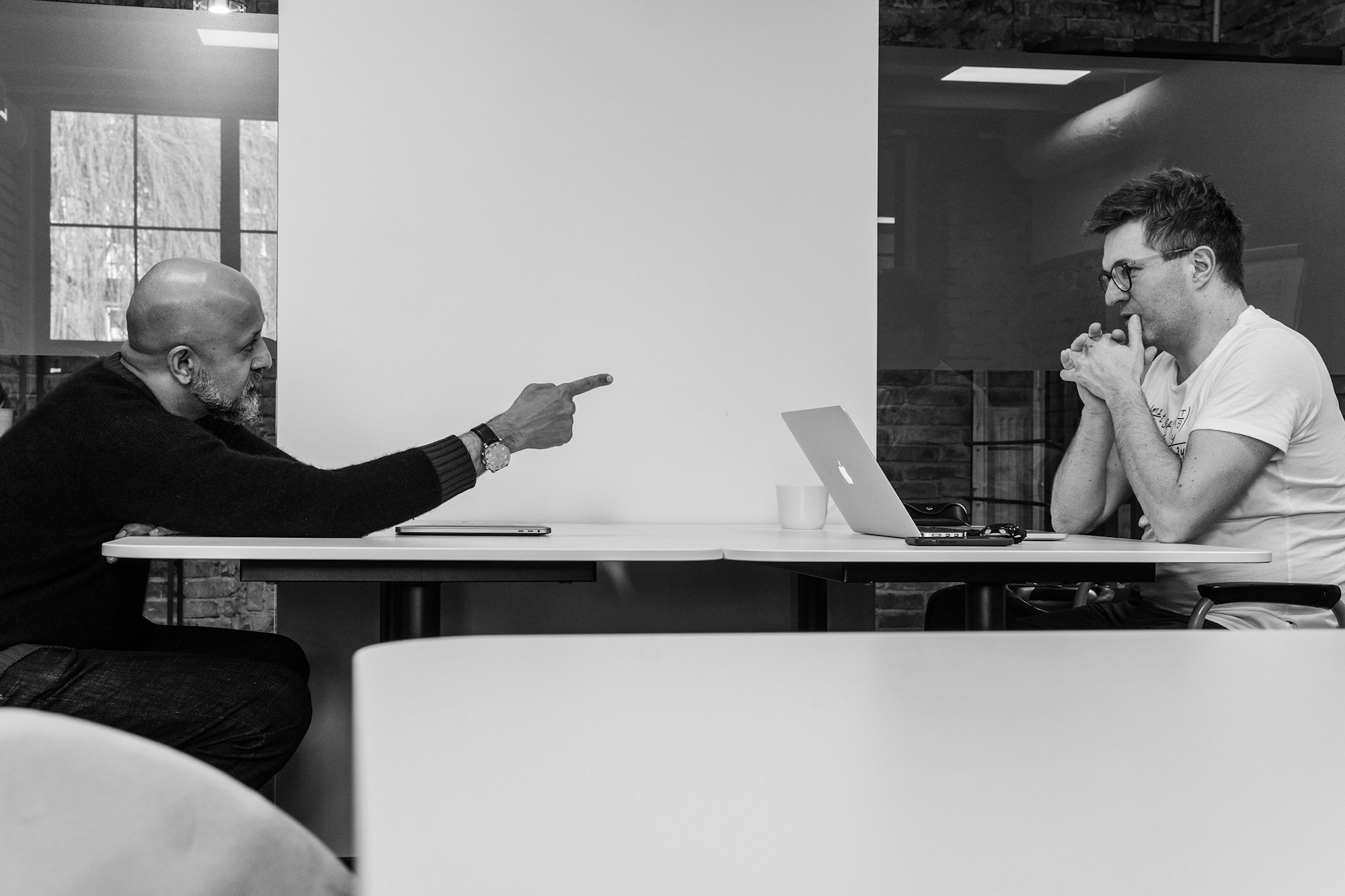 one man pointing his finger at another in an office environment