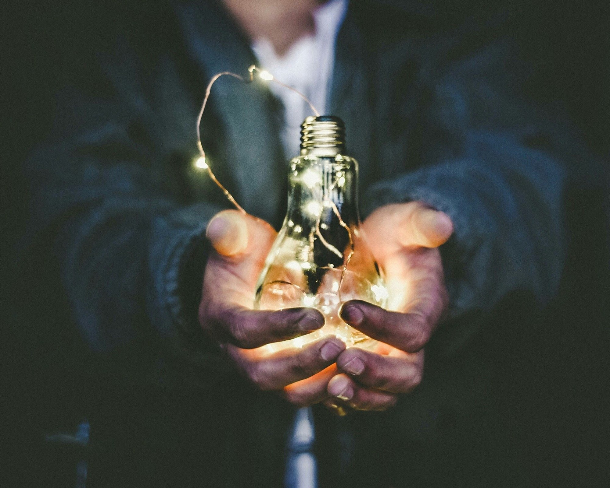 hands holding light bulb