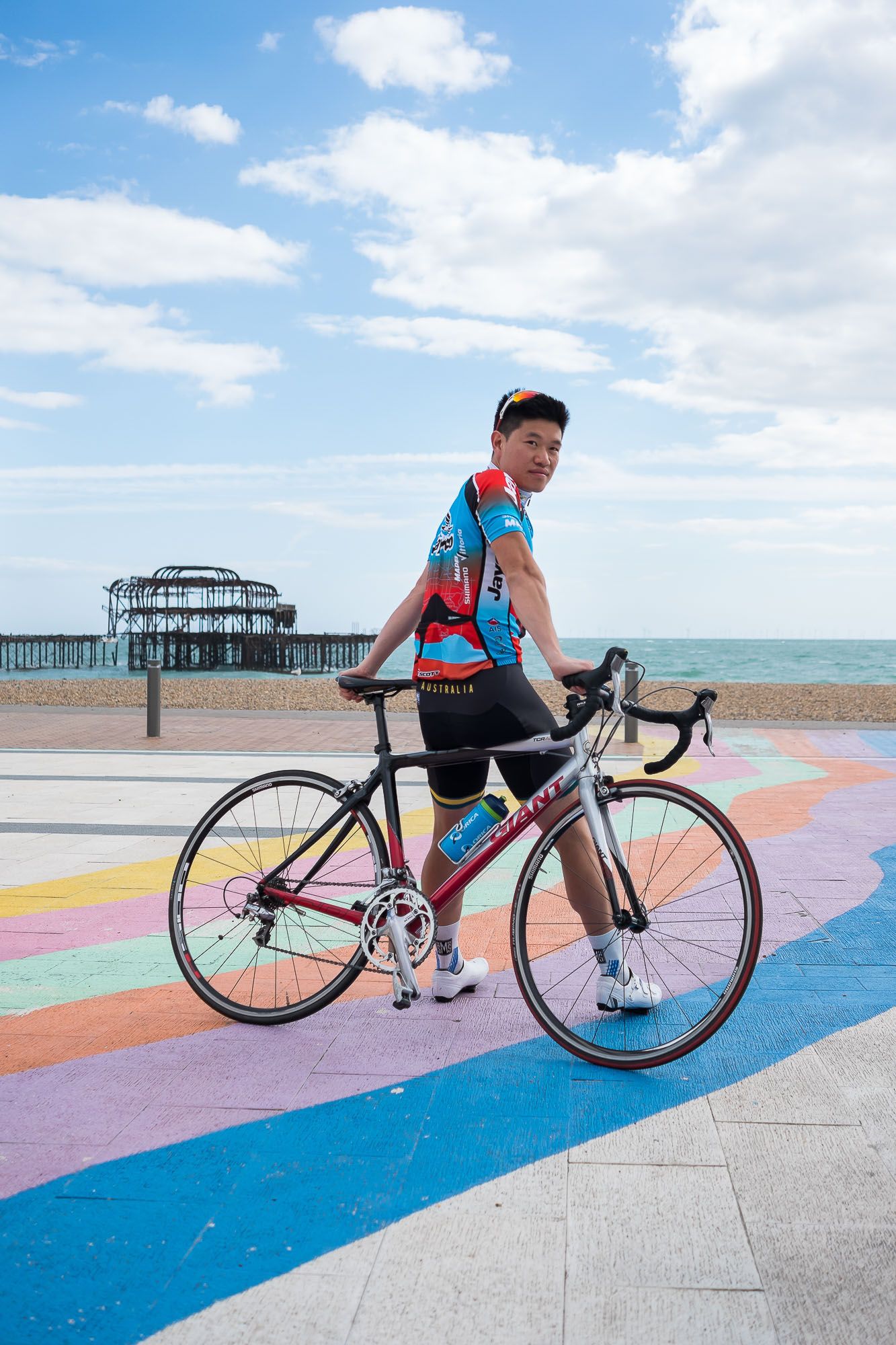 Man leaning on a bicycle in front of the West Pier in Brighton