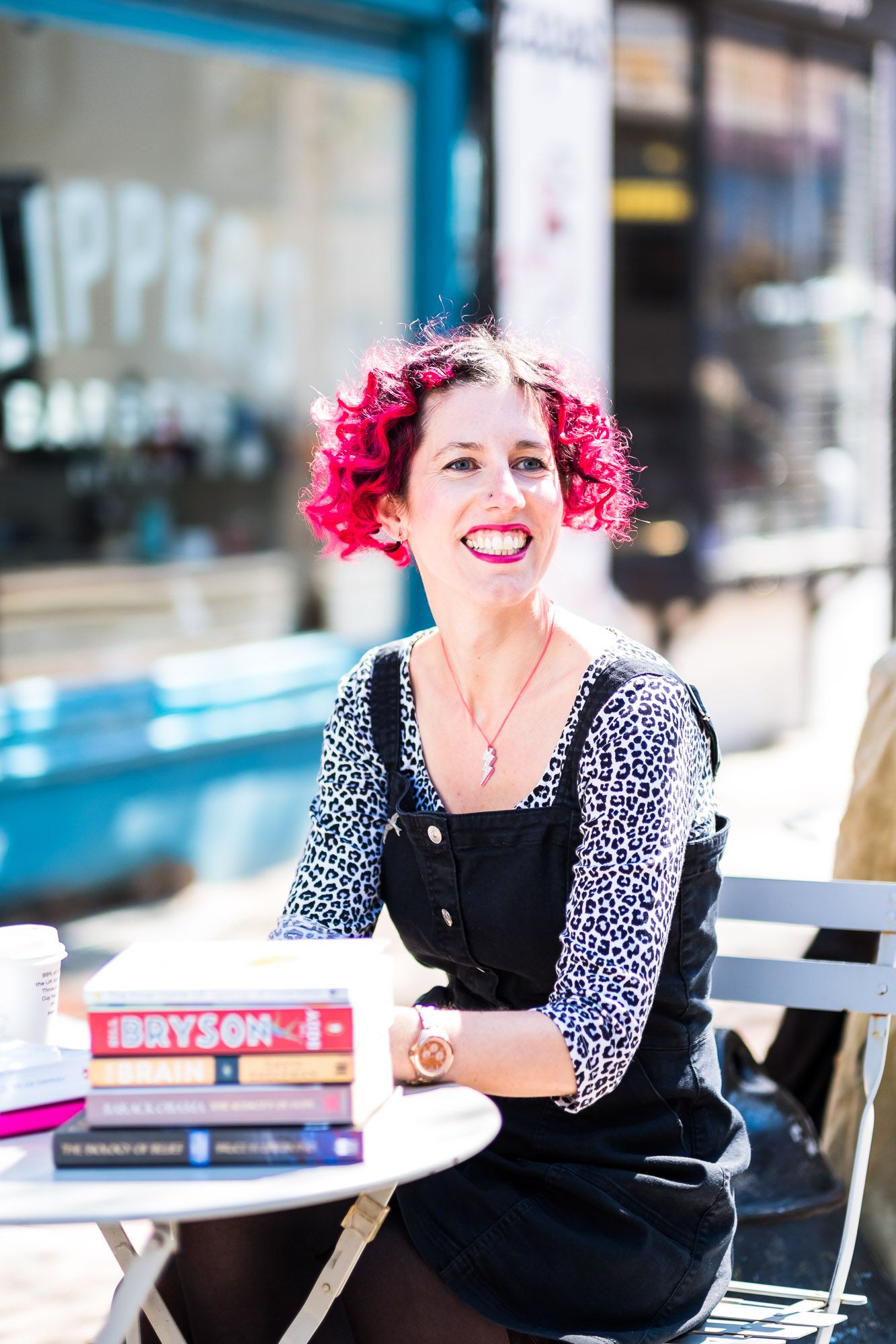Health coach Lauren Stoney sitting at a table outside Flour Pot cafe in Brighton  smiling
