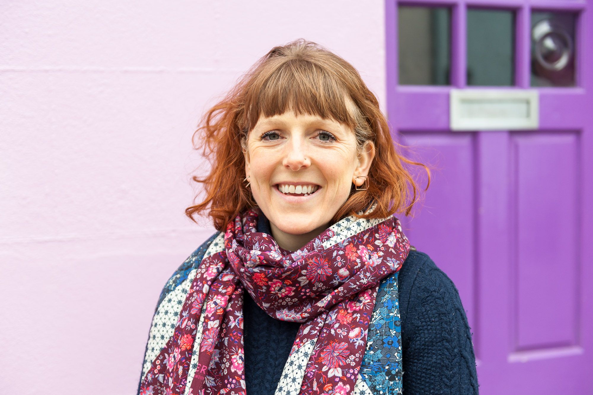 Woman standing in the street next to a purple door in Brighton