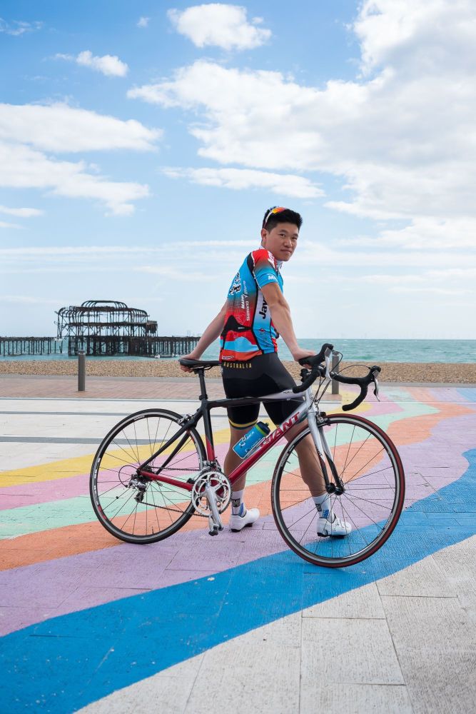 Cyclist leaning on his bicycle in front of the West Pier in Brighton