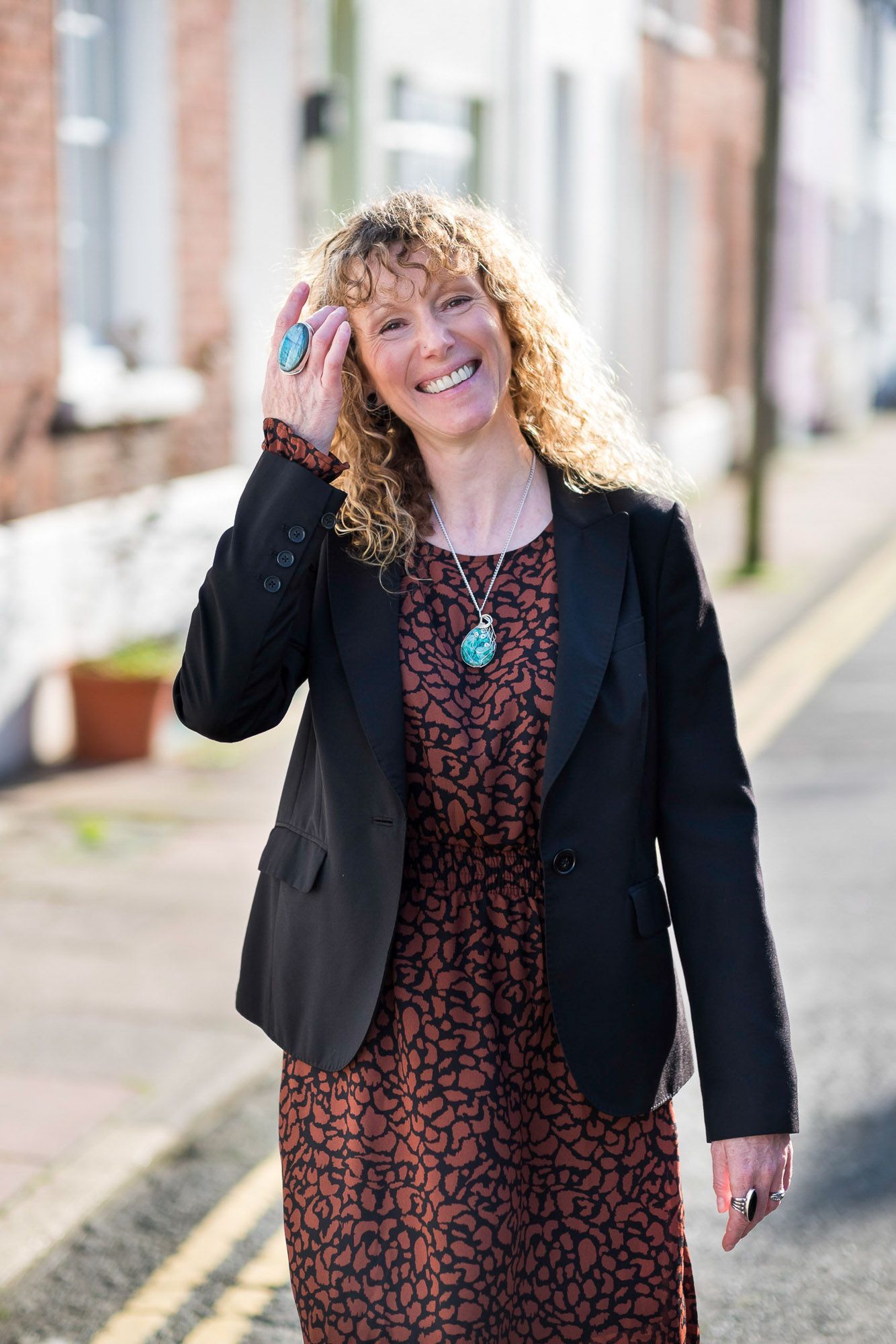 Leadership coach Jo Murfin standing in the street in Brighton touching her head