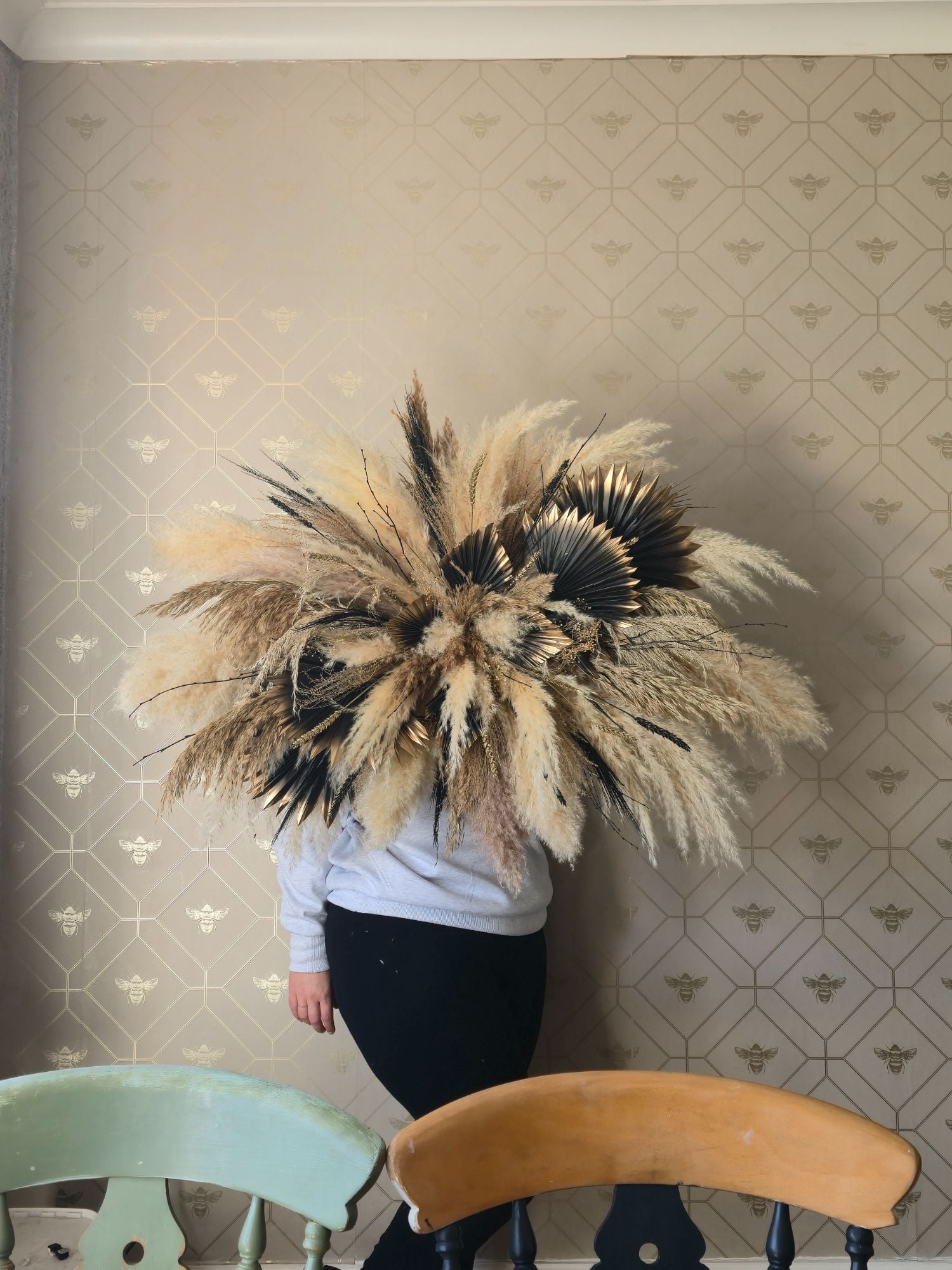 large pampas grass decoration with neutral tones, and accents of black and gold