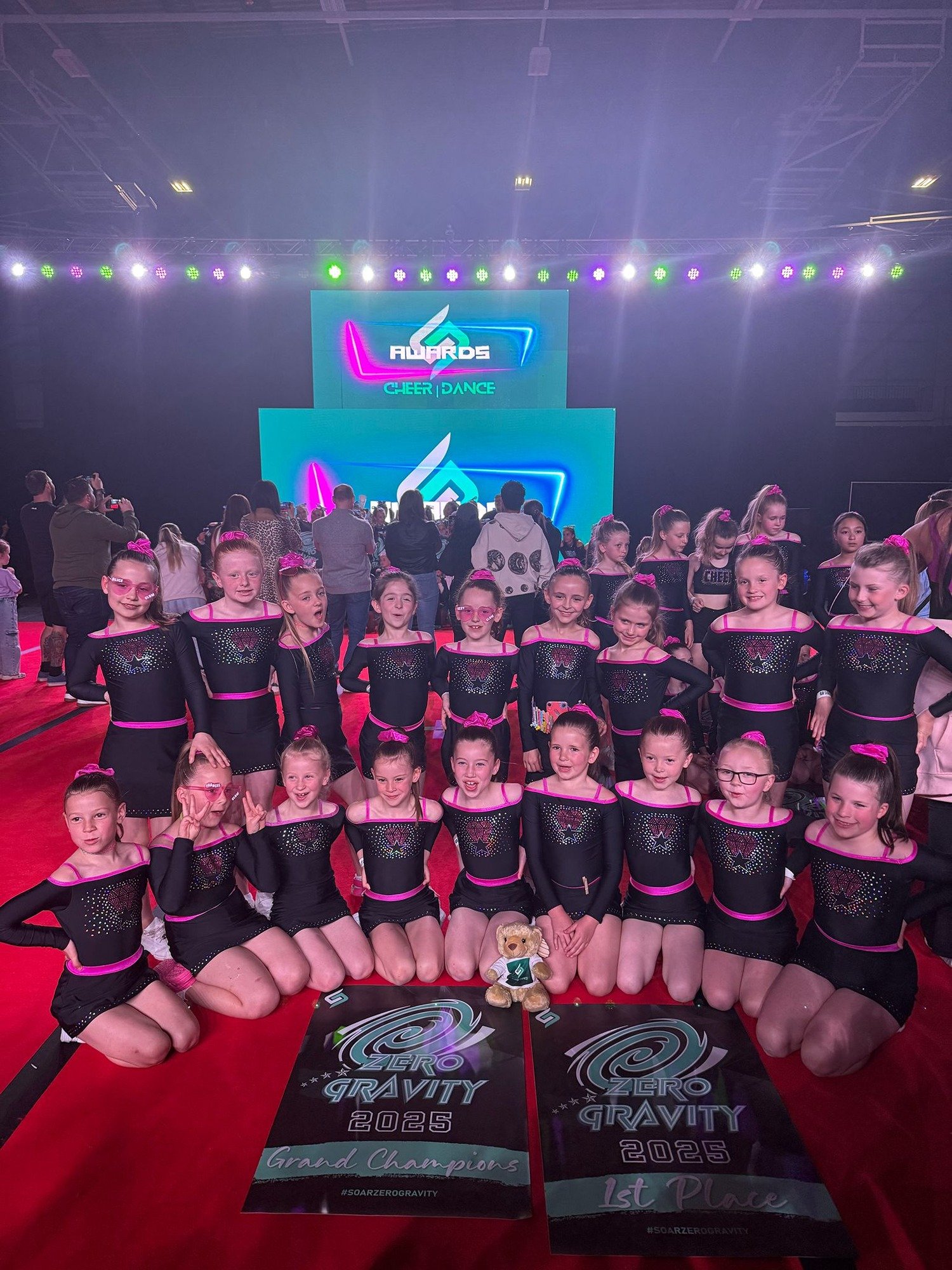A group photo of young girls in cheer outfits all smiling.