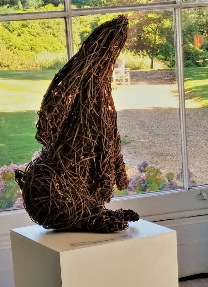 Willow moon gazing hare made from willow wars are down laying against back sitting on a plinth 
