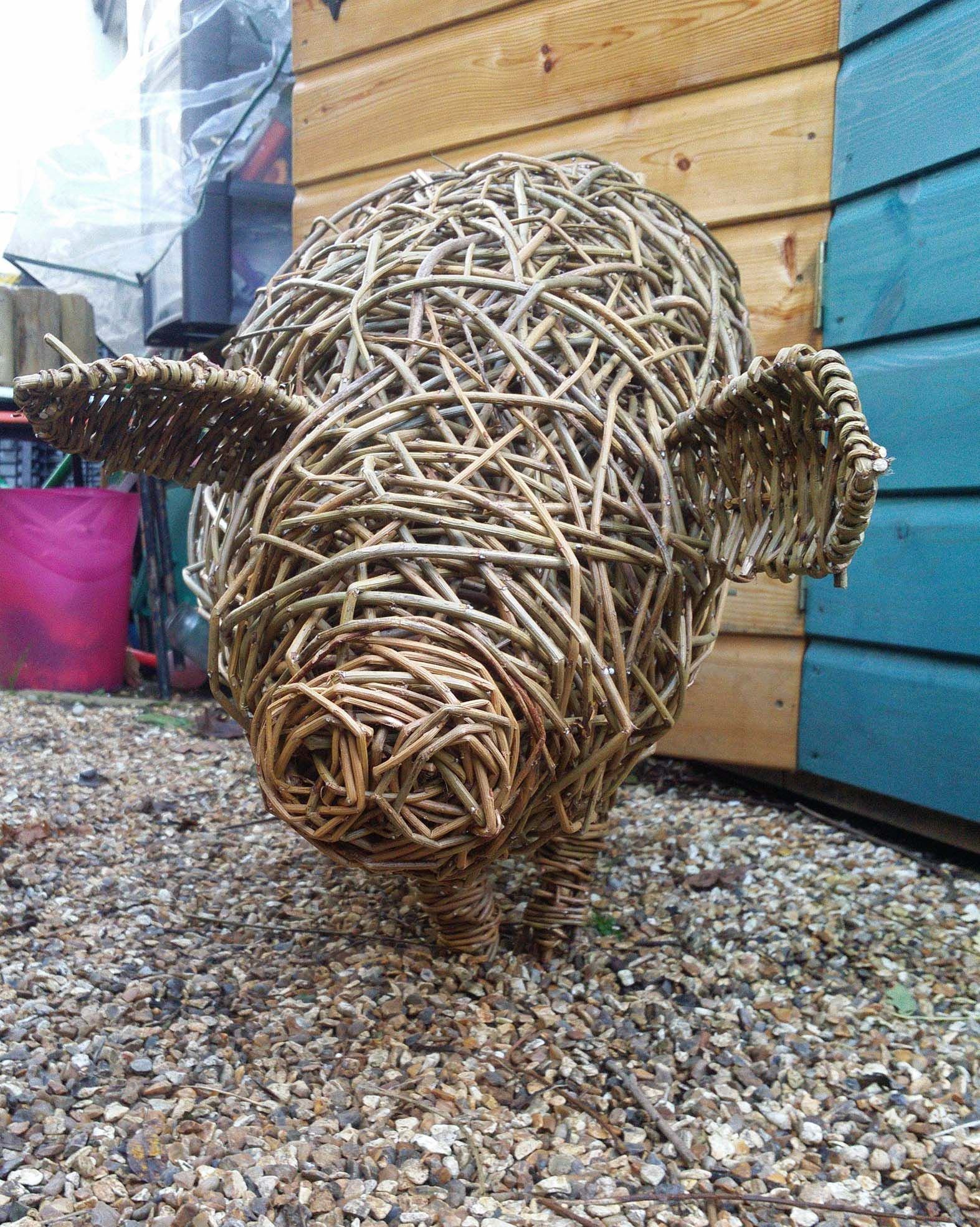 wilow pig  sculpture, standing on gravel ,front view  by willow and  crafts