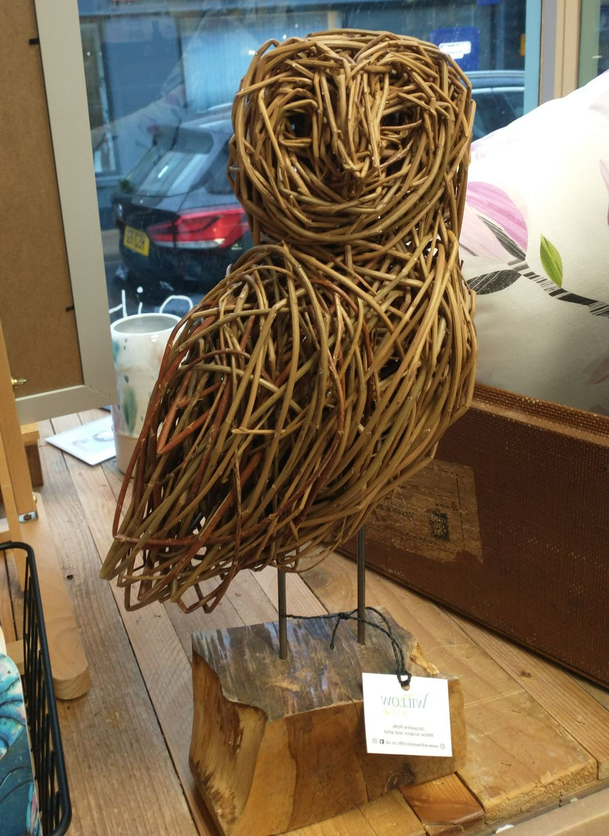 small willow barn owl standing on plinth   placed on wooden shelf 