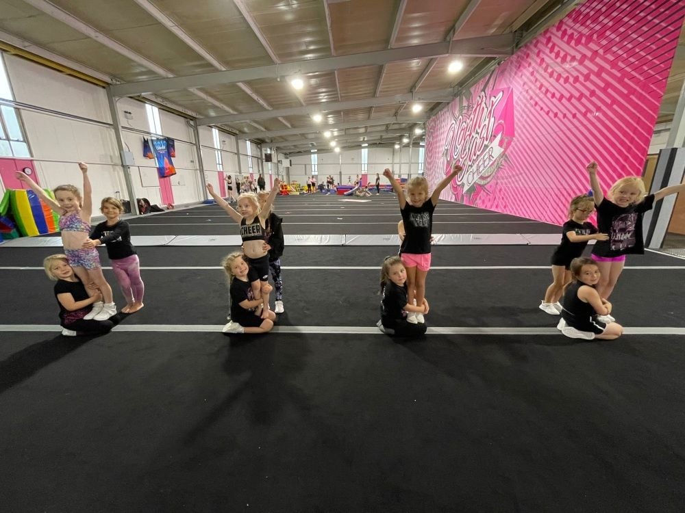 Four groups of three girls doing cheer.