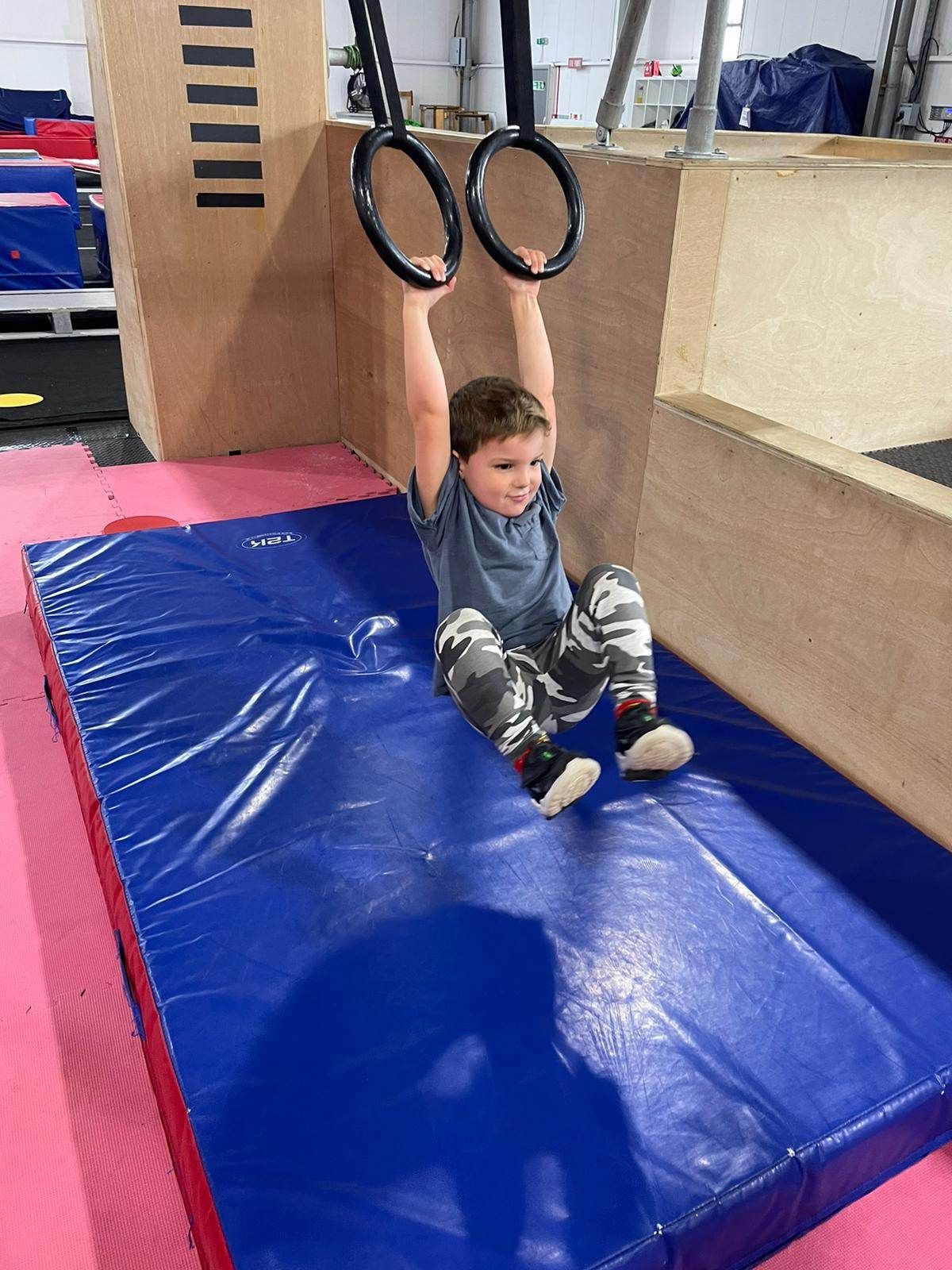 A boy about to land on a crashmat.