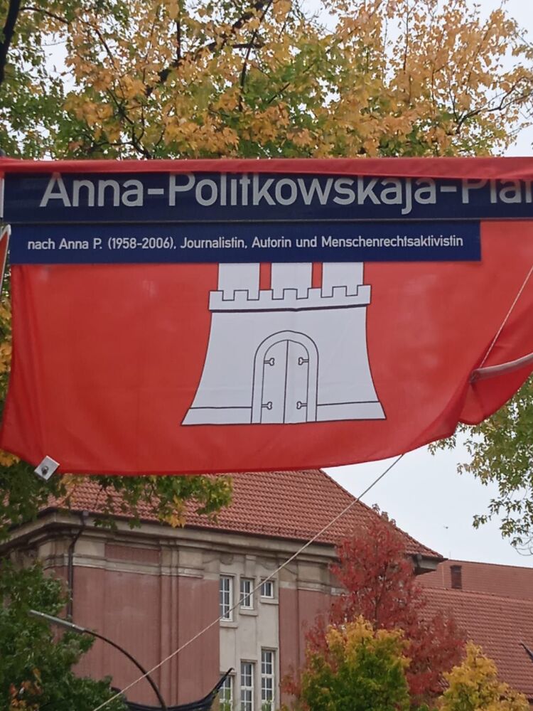 ÐÐ´Ñ€ÐµÑÐ½Ð°Ñ Ñ‚Ð°Ð±Ð»Ð¸Ñ‡ÐºÐ° ÐÐ½Ð½Ñ‹ ÐŸÐ¾Ð»Ð¸Ñ‚ÐºÐ¾Ð²ÑÐºÐ¾Ð¹ Ð½Ð° Ñ„Ð¾Ð½Ðµ Ñ„Ð»Ð°Ð³Ð° Ð“Ð°Ð¼Ð±ÑƒÑ€Ð³Ð°