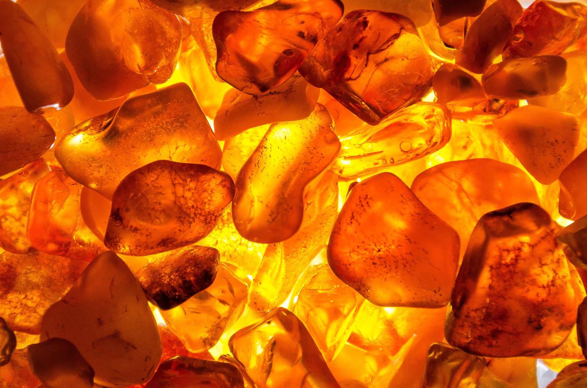 overlapping golden pieces of amber with the light shining through from behing to reveal the beauty of each piece.