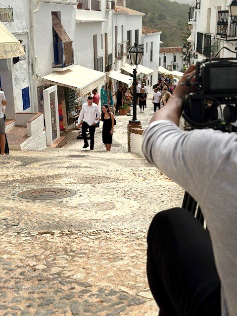 A young couple wander the beautiful old town streets of Frigiliana, enjoying the blue traditional doors on their way to siesta