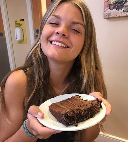 A young woman holding a bar of handmade Frigiliana artisan chocolate, showcasing the local flavors and traditional craftsmanship of the Axarquia region.