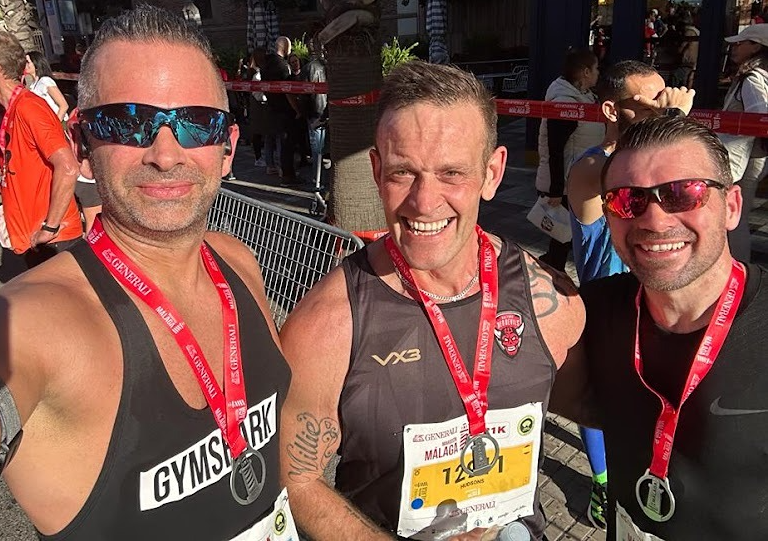 Three athletic men competing in a high intensity trail run through the mountains of Malaga, showcasing the rugged terrain and competitive spirit of the Aguanosos Trail events in Frigiliana.