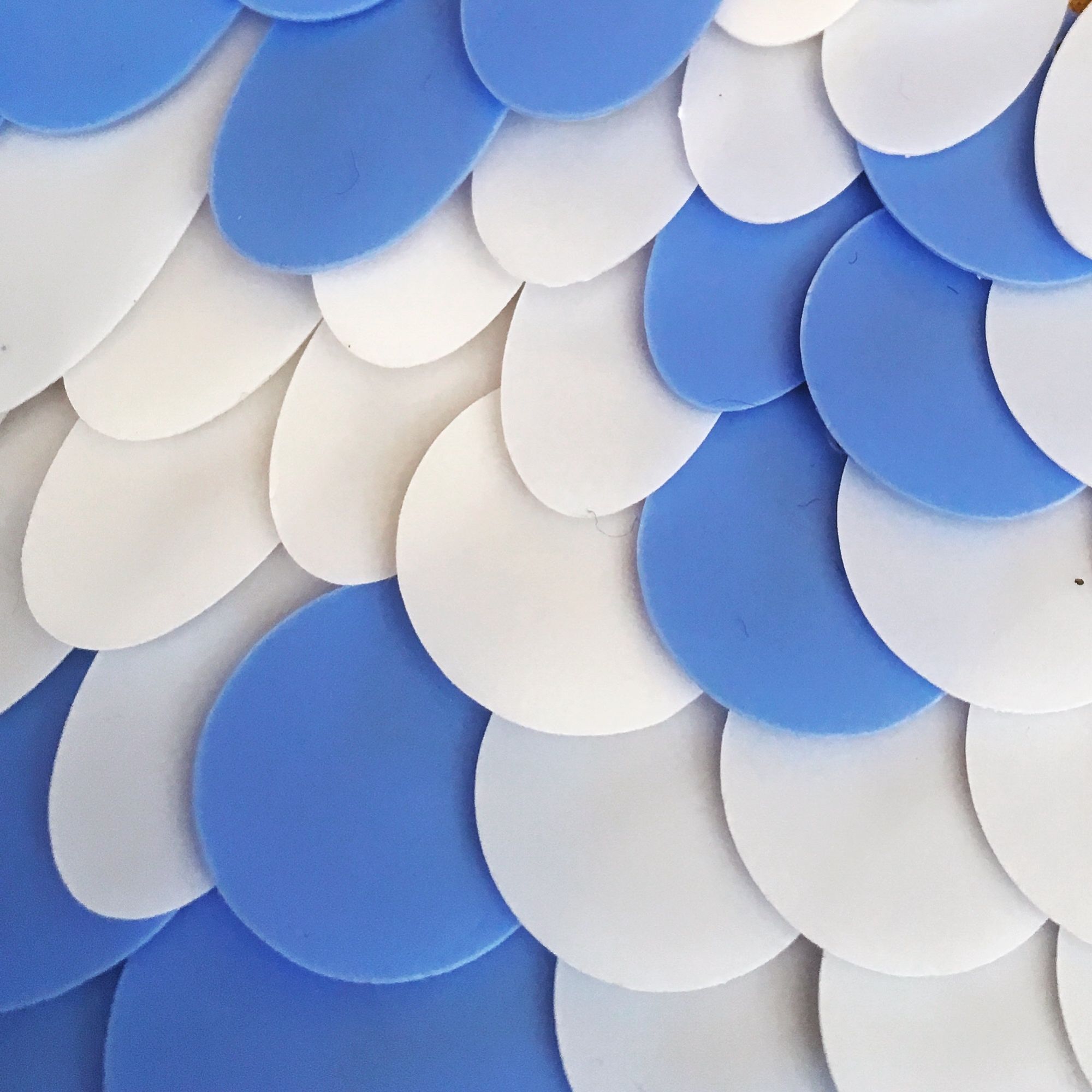 Opaque blue and white sequins made from biobased natural feedstock