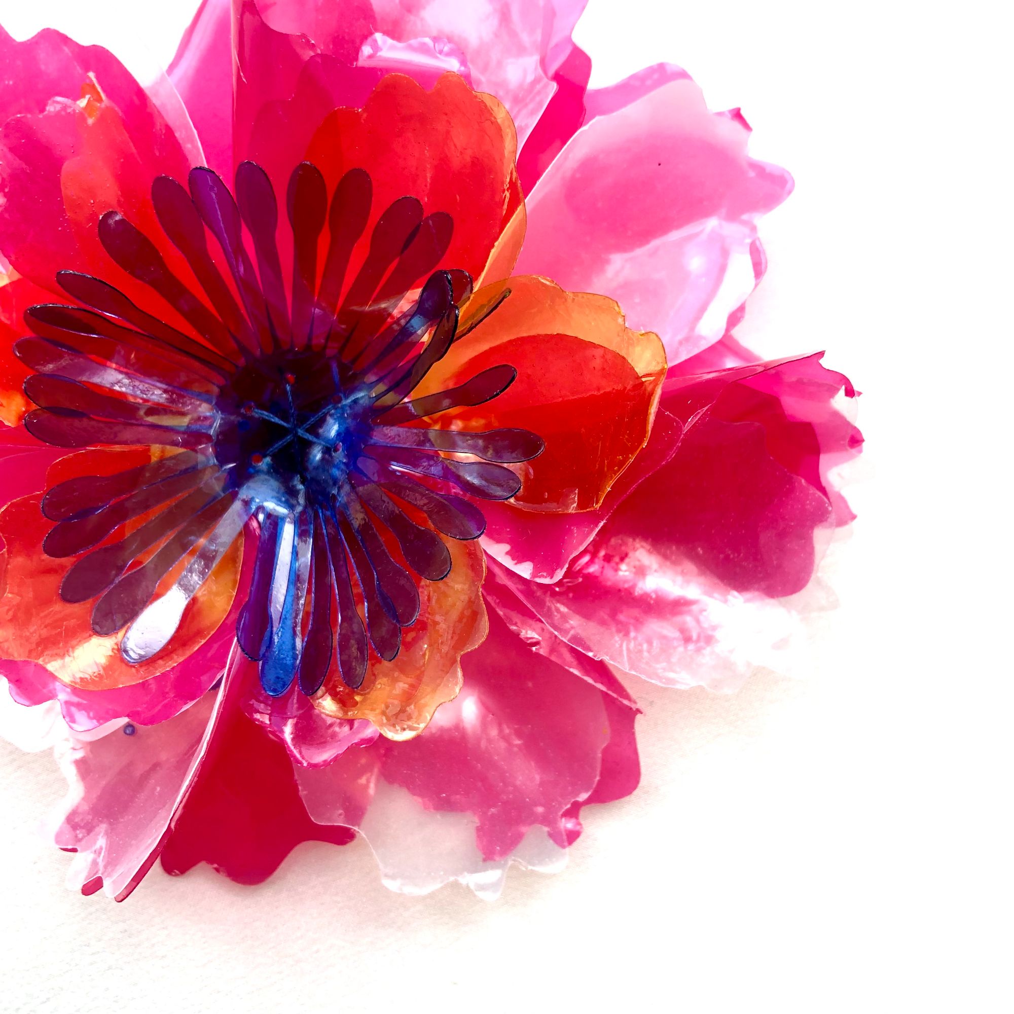 Flower made from bioplastic sequins in pink, yellow and blue