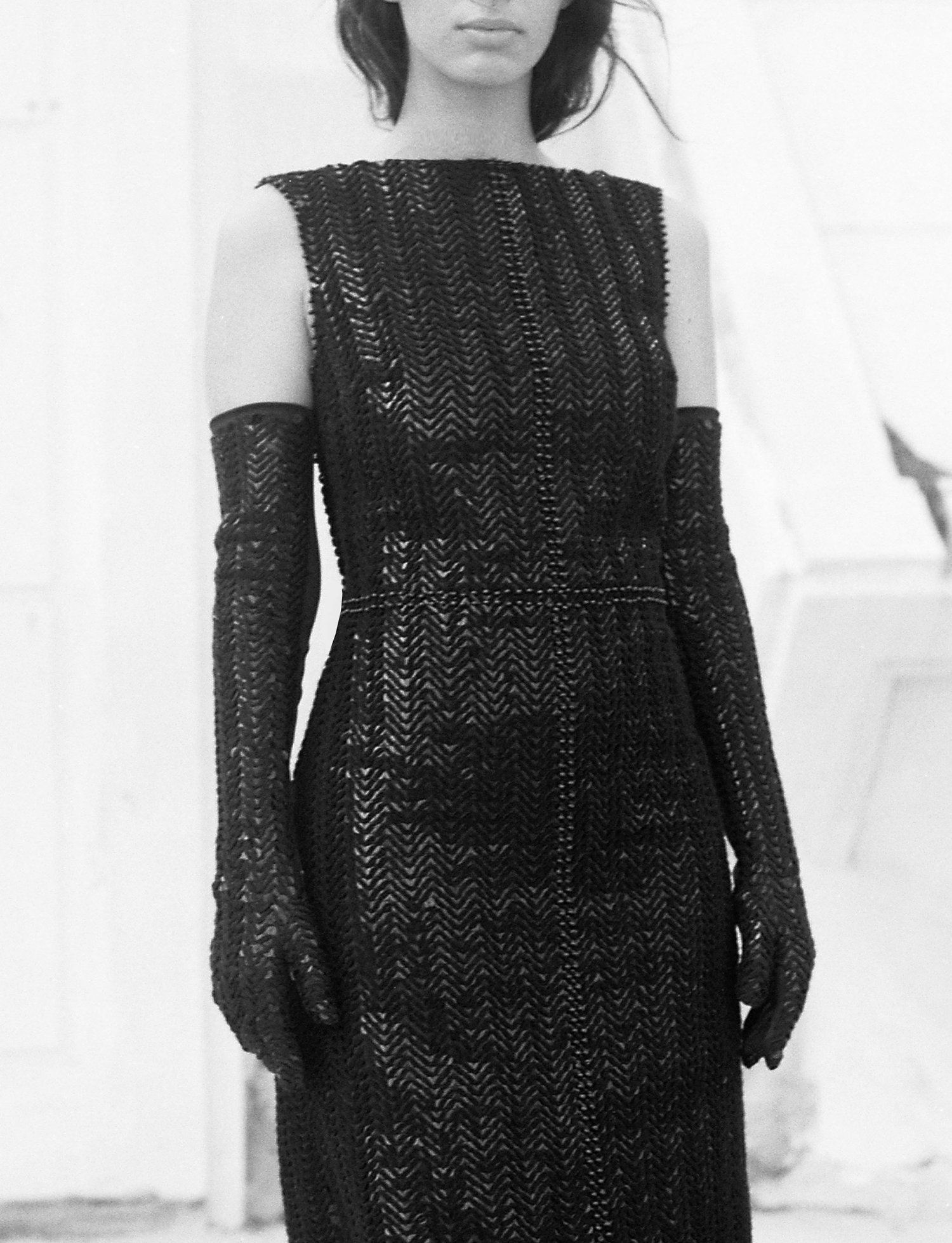 Model wearing black sequinned sleeveless dress and long black sequinned gloves