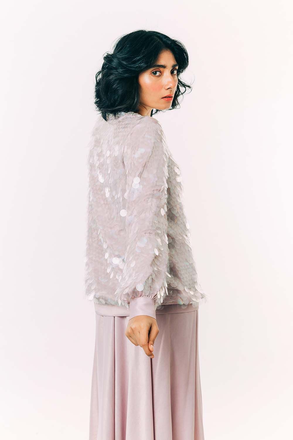 Model wearing a lilac jumper covered in clear rainbow sequins