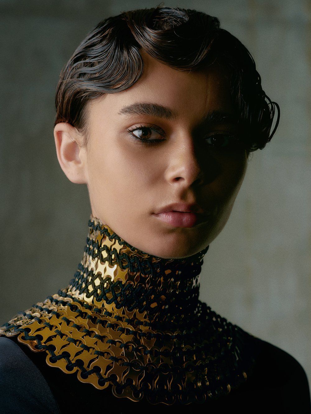 Model wearing a large gold neck piece made from bespoke cut pieces of sequin film and stitched together