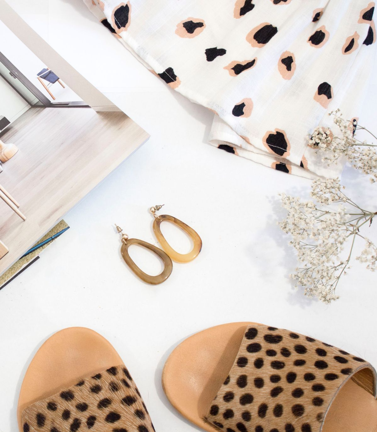 Co-ordinating animal print blouse, shoes and earrings with a magazine and flowers