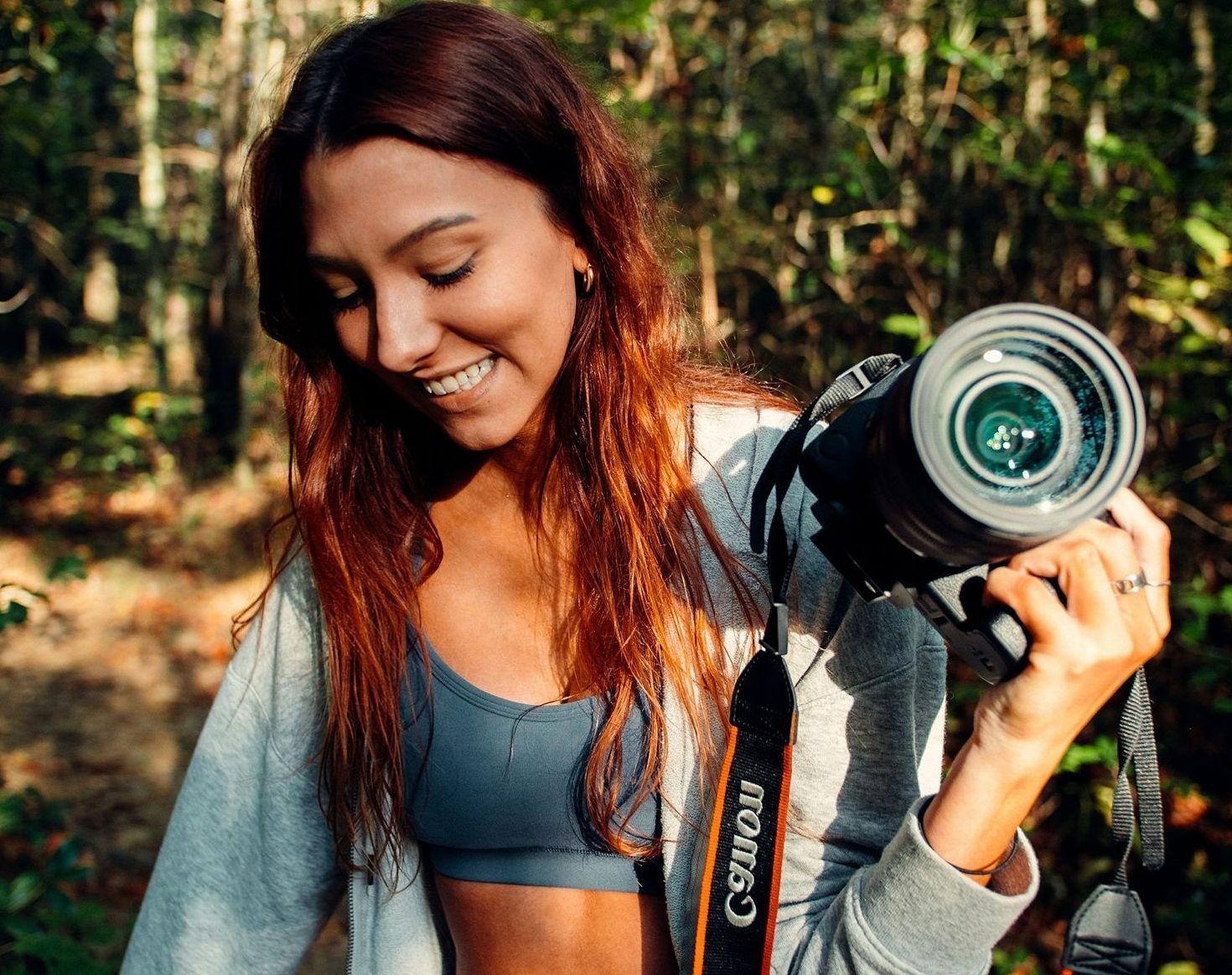 Female brand shoot photographer in wooded area with camera in her hand