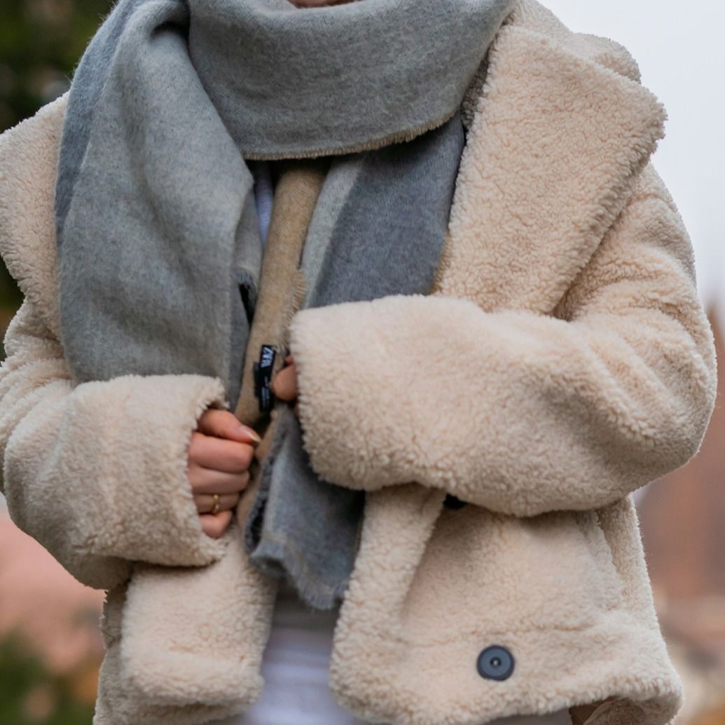 Woman who has had colour analysis in surrey in cream borg jacket, grey scarf and white top