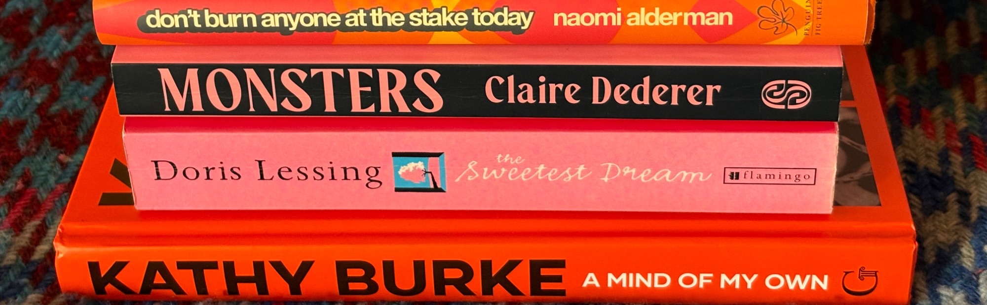 A stack of books on a blue and pink blanket. Kathy Burke A Mind of My Own, Dorris Lessing The Sweetest Thing, Monsters Claire Dederer, Naomi Alderman Don't Burn Anyone At The Stake Today, AI, disintermediation, and the free web.
