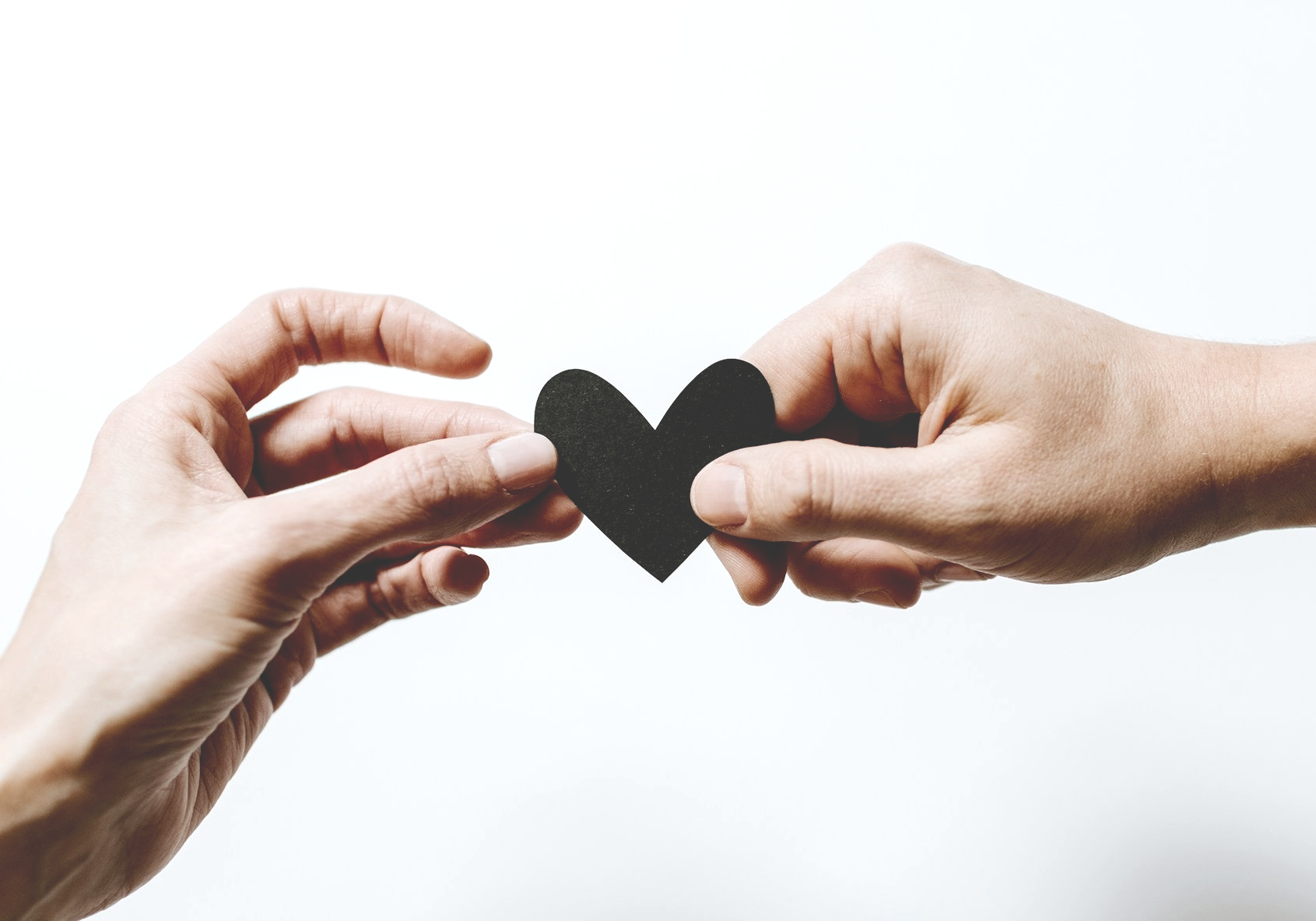 two hands holding paper heart