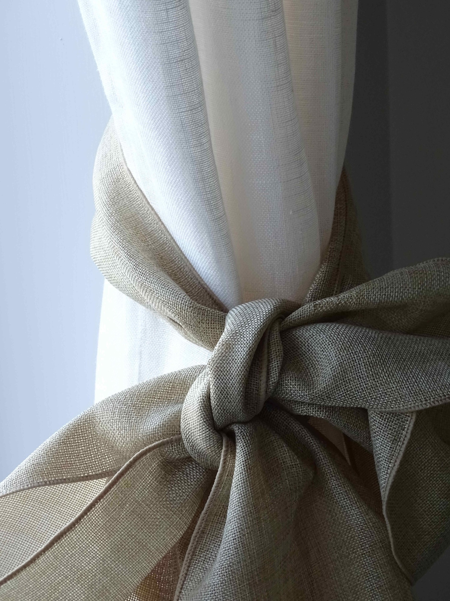 Soft linen curtain tied in a bow, reflecting the gentle, calming atmosphere of Lucyâ€™s natural facial studio.