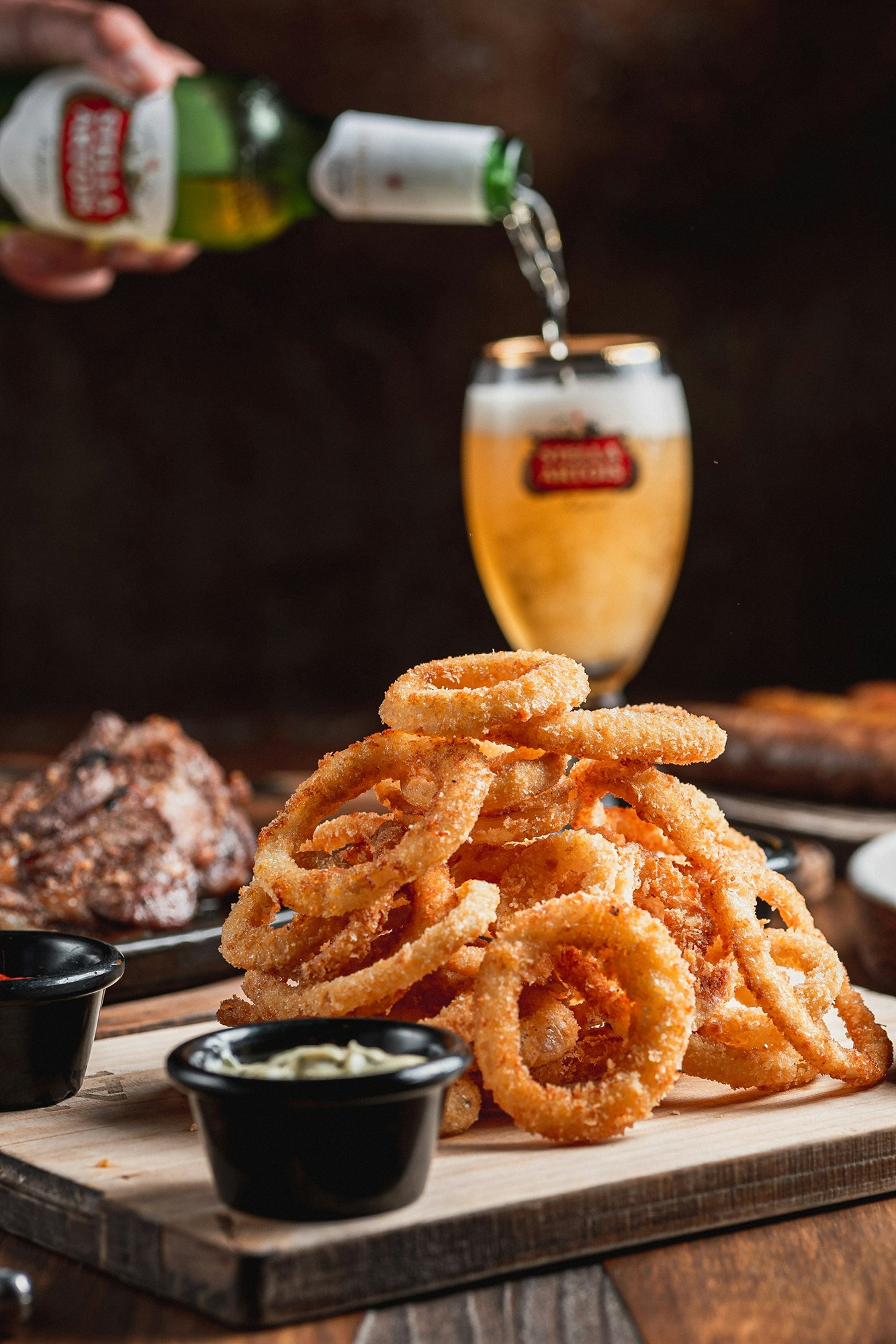 beer-poured-into-glass-next-to-onion-rings-AYB1ehtP-BY.jpg