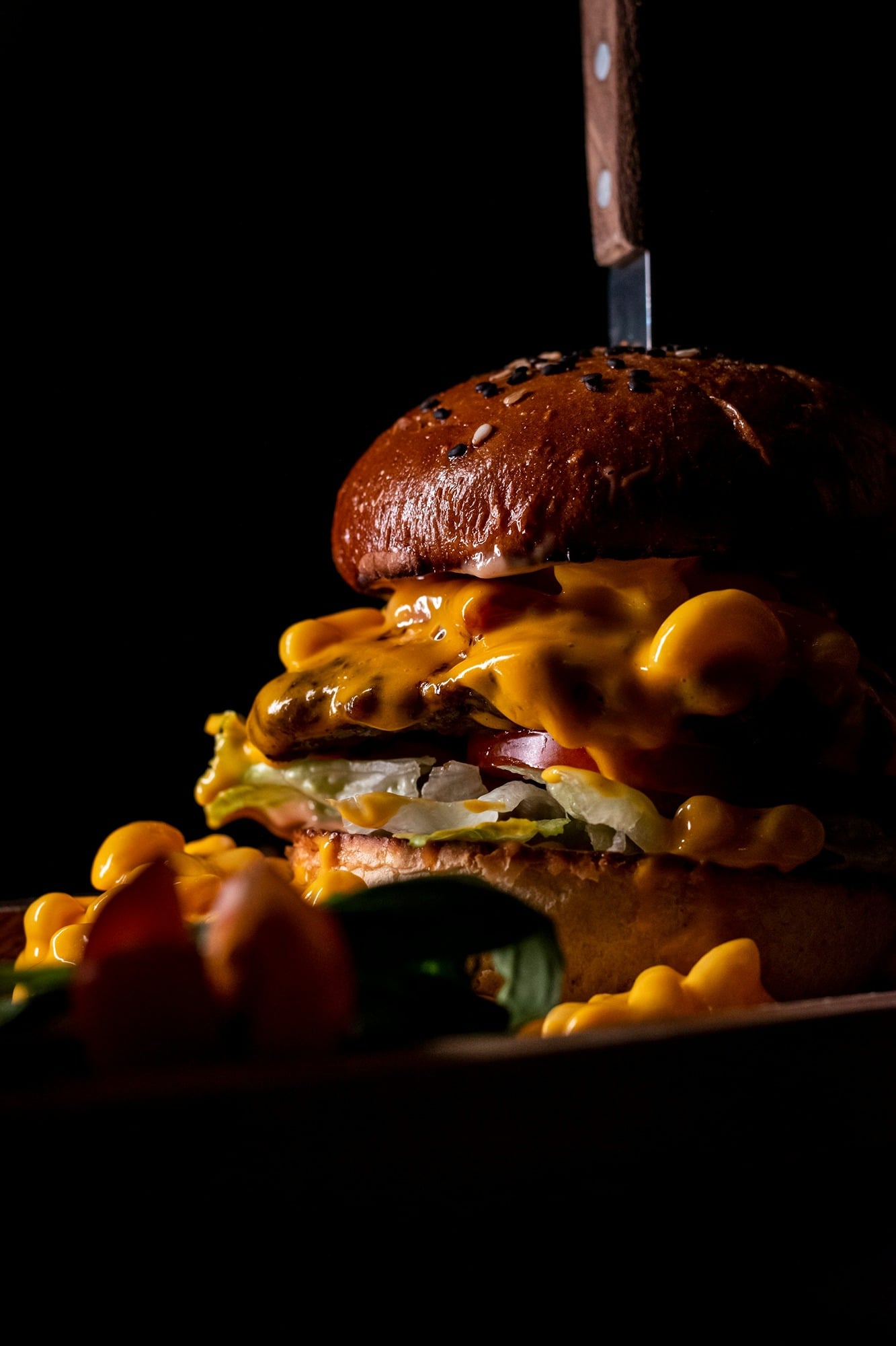 a-cheeseburger-on-a-plate-with-a-knife-stuck-in-it-AlUsEzlZfCw.jpg