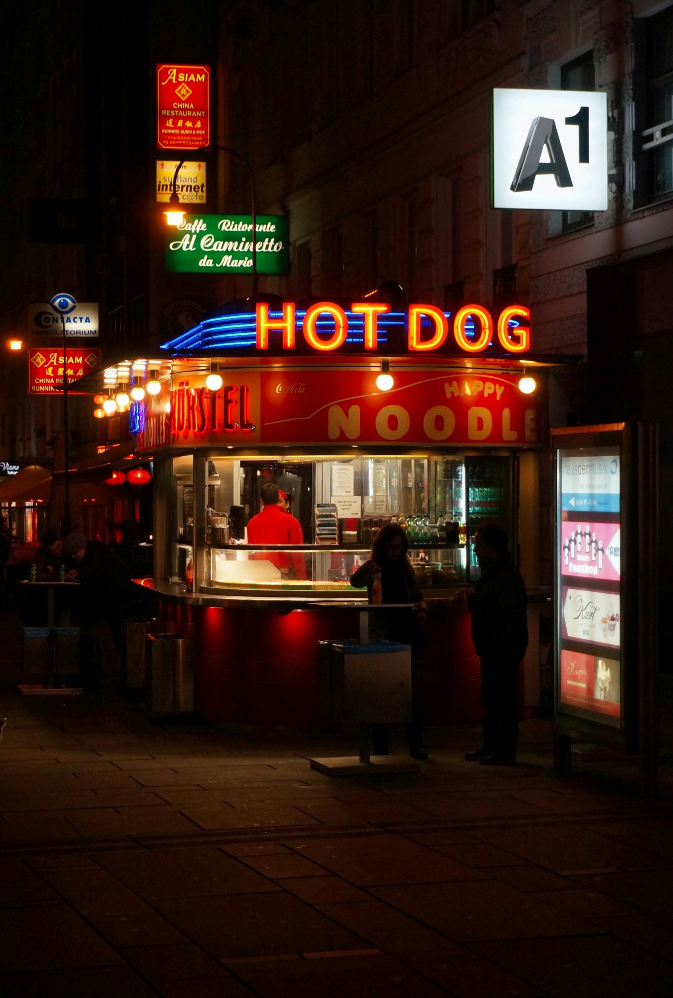 people-walking-on-sidewalk-near-red-and-white-store-during-nighttime-4PzOI1