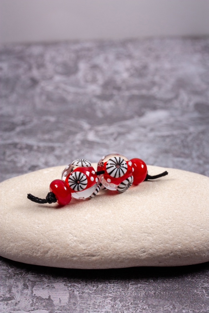 Red bead pair of round encased beads with black and white murrini
